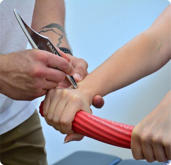 A chiropractitioner displaying IASTM (Instrument Assisted Soft Tissue Massage)